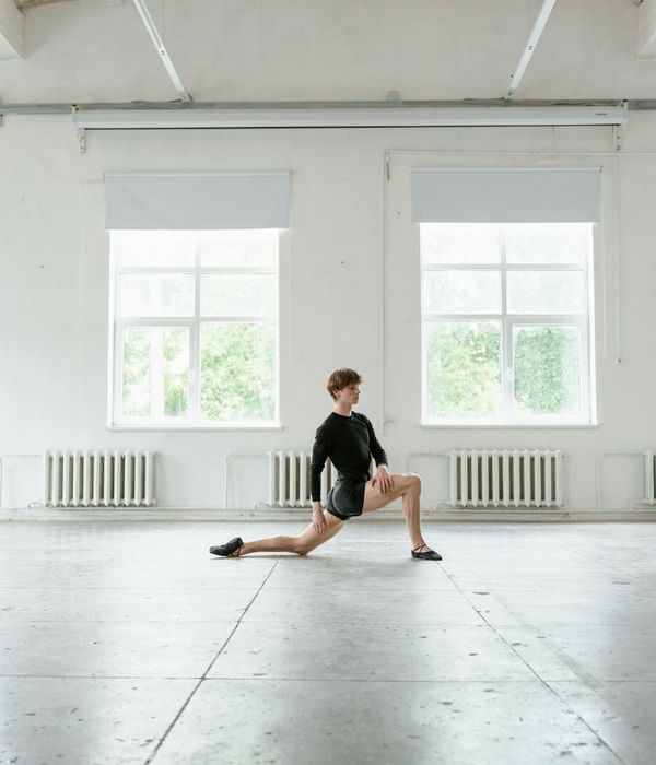 Teenager practicing a balancing yoga pose in a bright studio.